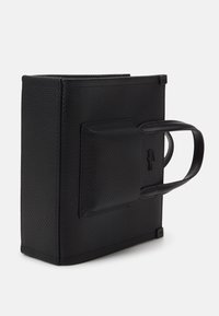 Borsa nera con texture, dalla forma strutturata, con due manici corti e una tasca frontale. Il materiale sembra sintetico con una finitura opaca.