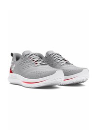 Scarpe da ginnastica grigio chiaro con tomaia in rete testurizzata, dettagli rossi e suola in gomma bianca. Design a profilo basso con chiusura con lacci.
