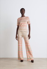 Set of matching top and pants in a soft, lightweight fabric. Features a striped pattern in pastel colors with short sleeves and flared pants.