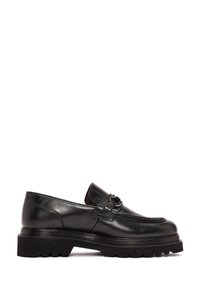 Mocasines de cuero negro con punta redonda, que presentan una hebilla decorativa y una suela gruesa y acanalada. Acabado suave con costuras mínimas.