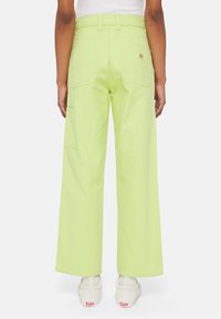 Vaaleanvihreät leveälahkeiset housut, valmistettu puuvillasta, joissa on takataskut ja sivutasku. Yhdistetty valkoisiin tennareihin.