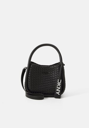 Bolso de mano de cuero tejido negro con asa superior redondeada, correa de hombro desmontable y etiqueta con el logo plateado de DKNY colgando en un lado.