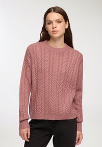 Sweter w warkocz w kolorze mauve, z okrągłym dekoltem, długimi rękawami i prążkowanymi mankietami. Projekt prezentuje teksturowany wzór na całej powierzchni.