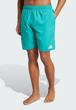 Tirkizne kupaće gaće izrađene od laganog materijala. Imaju elastičnu waistband i bijeli adidas logo na donjoj lijevoj strani.