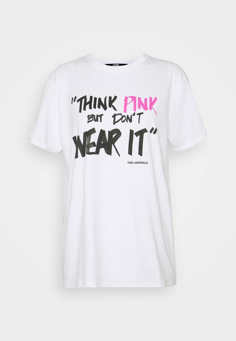 T-shirt di cotone bianca con maniche corte, caratterizzata da testo in grassetto nero e rosa: "PENSA IN ROSA ma non INDOSSARLO" e un logo in basso.