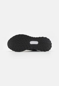 Schwarze Sportschuhsohle mit tiefen, strukturierten Rillen für besseren Halt. Enthält ein weißes, ovales Ausschnitt in der Mitte und hat ein flaches Design.