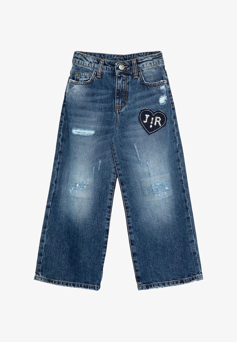 Jeans in denim di un blu medio con un design a gamba larga. Presentano toppe strappate e una toppa a forma di cuore nera con scritta bianca "J/R."