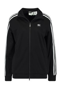 Chaqueta negra con cremallera hecha de un tejido suave, que presenta un cuello alto, dos franjas blancas a los lados y un logo bordado en el pecho.