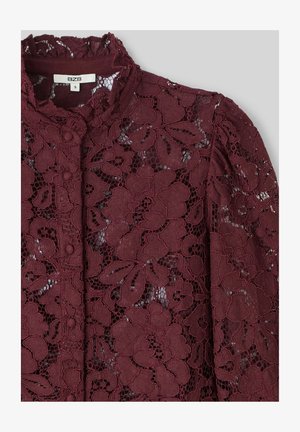 Blouse en dentelle bourgogne avec des motifs floraux, col montant et détails de boutons. Texture transparente avec une apparence tactile et superposée.