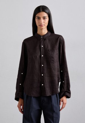 Camicia button-up marrone scuro con una vestibilità rilassata, colletto, maniche lunghe, tasca sul petto e bottoni bianchi.