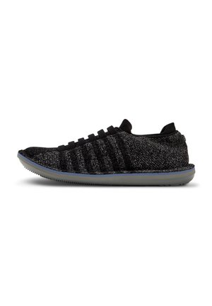 Zapatillas de punto negras y grises con parte superior texturizada, con cordones elásticos y una suela de goma flexible en gris claro.