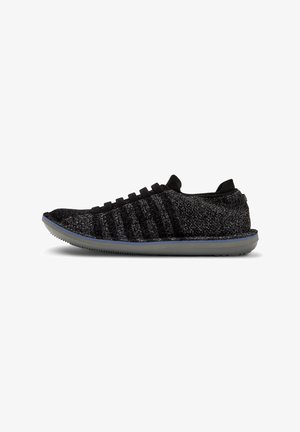 Schwarzer und grauer Stricksneaker mit einer strukturierten Oberseite, ausgestattet mit elastischen Schnürsenkeln und einer flexiblen, hellgrauen Gummisohle.