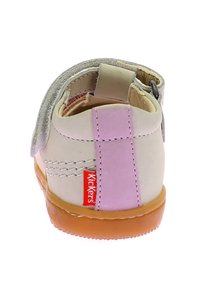 Scarpa da bambino Kickers, in pelle beige con un accento rosa, cinturino in velcro, design arrotondato, suola in gomma e dettagli di cucitura visibili.