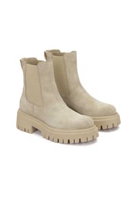 Bottines en suède beige avec panneaux élastiques sur les côtés, semelle en caoutchouc épaisse et semelle texturée. Bout rond et languette à l'arrière.