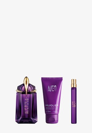 Botella de perfume púrpura con acentos dorados, tubo de loción corporal púrpura y un pequeño spray de viaje púrpura, todos con la marca Alien.