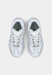 Weiße Sportsneaker mit einem glatten Lederobermaterial, tonal abgesteppten Nähten und sechs Ösenpaaren. Das Adidas-Logo ist auf den Innensohlen sichtbar.