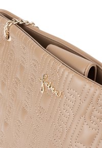 Beige læderhåndtaske med quiltet mønster, guld logo detalje og kædehåndtag. Har en glat tekstur og struktureret design.