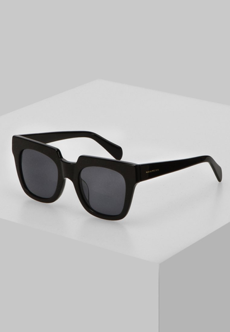 Black square sunglasses with dark lenses, glossy plastic frame, and thick arms. Notable square shape with rounded edges and minimal hardware.