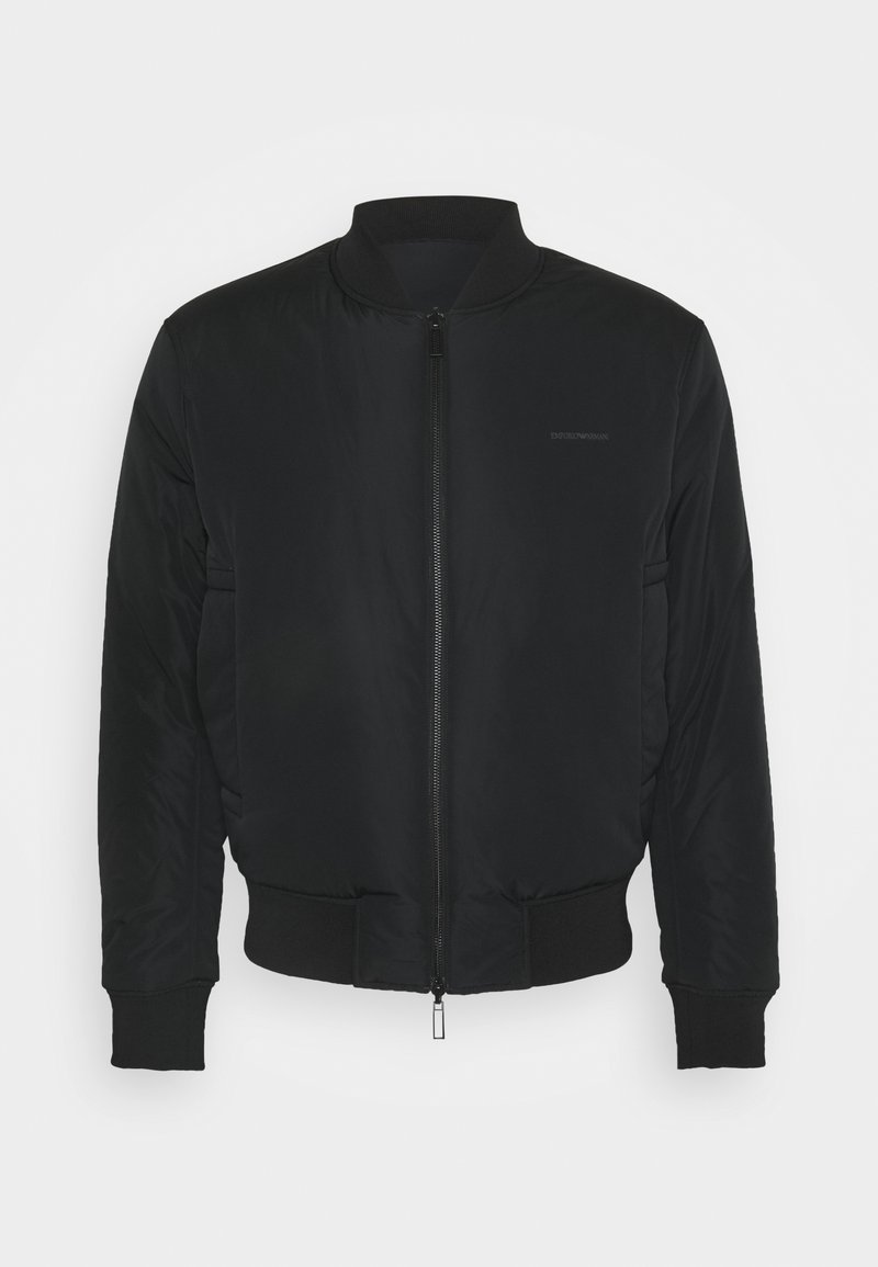 Veste bomber noire avec col, poignets et ourlet côtelés, avec une fermeture éclair à l'avant et des poches latérales.