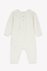 Cream knitted baby onesie with textured patterns, three buttons at the neck, and ribbed cuffs. Soft material and full-length design.