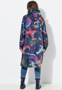 Trench lungo con cappuccio, caratterizzato da un motivo astratto colorato su sfondo blu navy. Realizzato in materiale leggero e impermeabile.