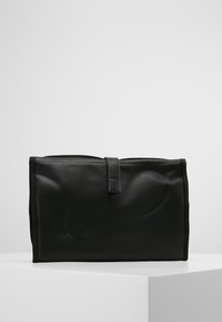 Black leather bag with a rectangular shape, featuring a smooth texture and a top flap secured by a strap. No visible hardware or patterns.