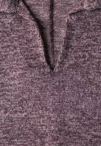 Gros plan d'un tissu tricoté violet texturé avec un col en V profond sur un pull ou un vêtement.