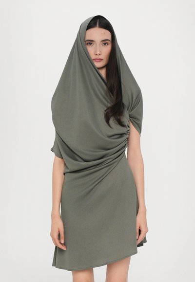 Abito drappeggiato in tessuto verde oliva, con una vestibilità ampia e scollo rotondo, texture morbida e orlo asimmetrico, che crea una silhouette fluida.