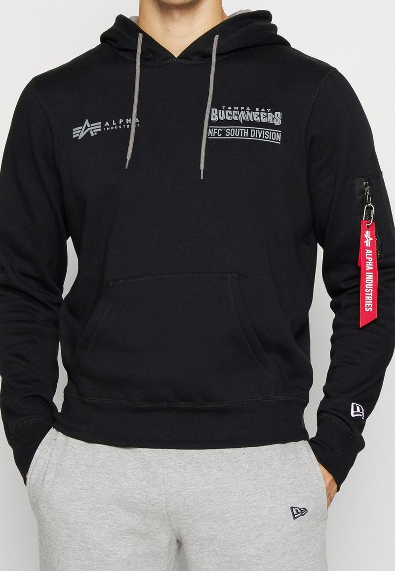 Felpa nera con tasca frontale, coulisse grigia, logo dei Tampa Bay Buccaneers, tasca con zip sulla manica con dettaglio rosso e polsini a costine.