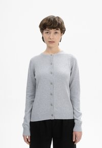 Helle graue Strickjacke aus weichem Material, mit Rundhalsausschnitt, langen Ärmeln und sechs Knöpfen an der Vorderseite. Sie hat gerippte Bündchen und Saum.