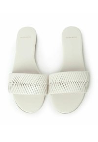Sandali bianchi con ampie cinghie testurizzate caratterizzate da un motivo a zigzag, suola piatta e design minimalista. Logo inciso sulla soletta.