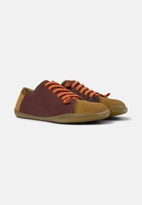 Scarpe marroni e bordeaux con lacci arancioni, caratterizzate da un morbido materiale superiore, punta arrotondata e suola in gomma flessibile.