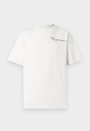 Bijela pamučna majica kratkih rukava, okruglog izreza, s crnim tiskanim natpisom na prsima na kojem piše "Carhartt Work in Progress 1989."
