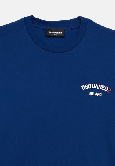 Μπλε μπλουζάκι με στρογγυλή λαιμόκοψη και λευκό-κόκκινο λογότυπο "DSQUARED2 MILANO" στο στήθος, καθώς και μαύρη ετικέτα DSQUARED2 με μέγεθος 14Y στο εσωτερικό του γιακά.
