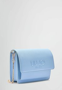 Borsa a tracolla blu chiaro realizzata in materiale sintetico texturizzato. Presenta una chiusura a patta magnetica, una tracolla in catena dorata e un dettaglio con logo impresso.