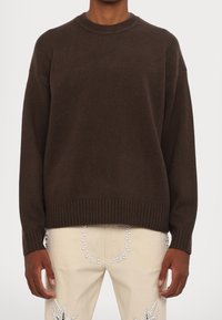 Dark brown knit sweater with a ribbed neckline and cuffs. The design features a relaxed fit, accentuating a smooth, textured surface.