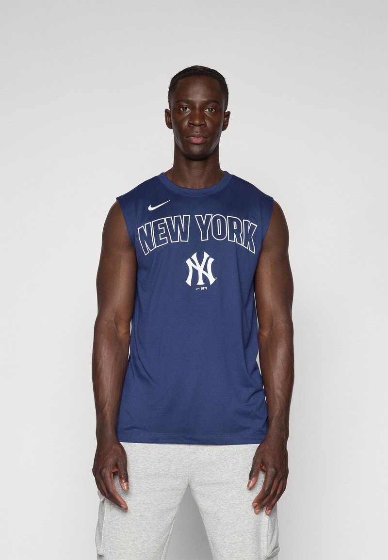 Camiseta sin mangas de Nike en color navy con el texto "NEW YORK" y el logo de los Yankees en blanco. Tela suave, diseño de cuello redondo, combinada con pantalones cortos grises.