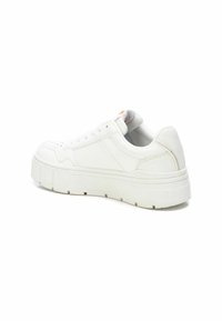 Zapatilla blanca con un upper de cuero liso, punta redonda, cierre de cordones y una suela de plataforma gruesa. Presenta costuras sutiles y perforaciones.