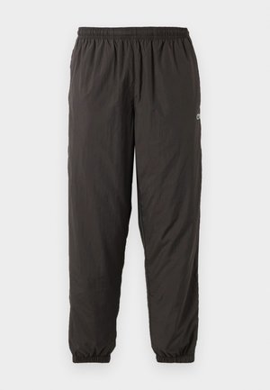 Pantaloni neri, leggeri, con vita elastica e vestibilità morbida. Presentano polsini elastici e un logo discreto di lato. Texture liscia.