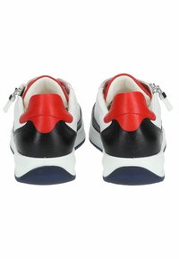 Sneakers in pelle bianca e nera con dettagli rossi, zip, collo imbottito e suola blu. Design low-top con superfici texture.