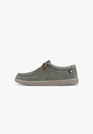 Chaussure slip-on en suède vert clair avec un bout arrondi, semelle en caoutchouc texturée et détail de lacets ronds décoratifs.