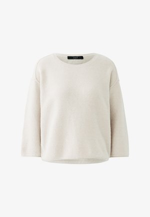 Cremefarbener Pullover mit Rundhalsausschnitt und langen Ärmeln, locker geschnitten und aus weichem Stoff, mit einem schwarzen Etikett im Krageninneren.