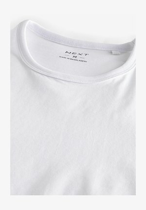 Valkoinen puuvillapaita, jossa on pyöreä pääntie, joka tarjoaa sileän tekstuurin ja hienovaraisen ribbaustekstin kauluksessa. Brändilogo näkyy kaulan sisäpuolella.