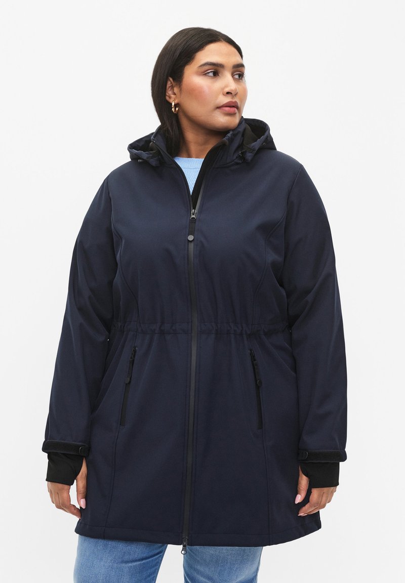 Námornícka nepremokavá parka s pásikom na stiahnutie v páse, so zapínaním na zips a dvoma bočnými vreckami. Obsahuje kapucňu a dlhé rukávy s rebrovými manžetami.
