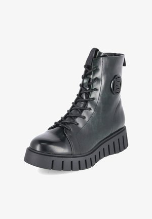 Bota negra de cuero alta con suela gruesa ranurada, punta redonda, cordones en la parte delantera y logo circular en el lateral.