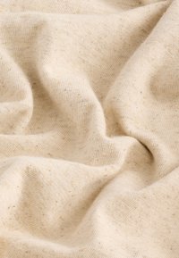 Țesătură bej deschis, texturată, cu o aparență moale; prezintă pete subtile și o suprafață ușor șifonată, sugerând un material natural.