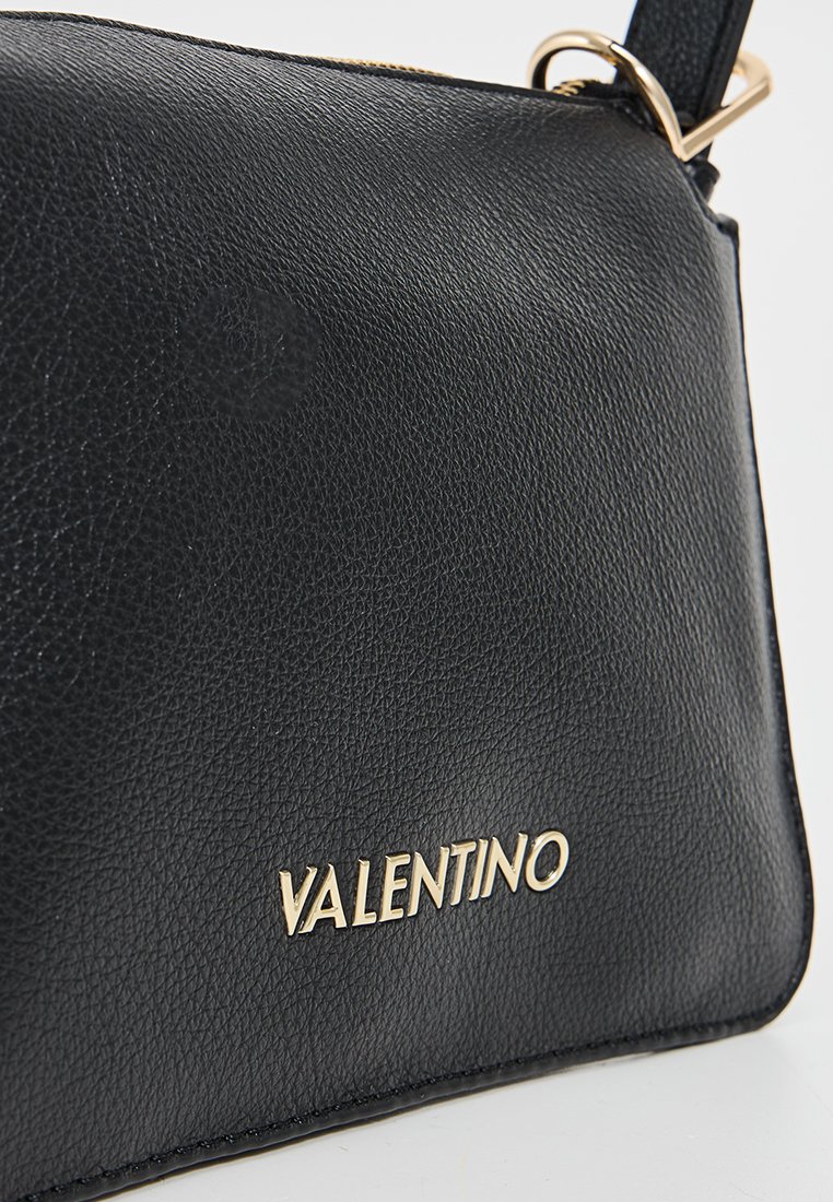 Schwarze Lederhandtasche mit strukturiertem Oberflächen, goldfarbener Hardware und dem eingeprägten Markennamen "VALENTINO" auf der Vorderseite.