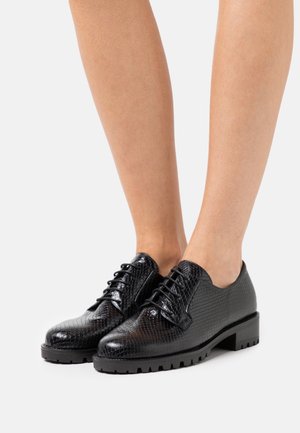 Chaussures noires à lacets en matière texturée imitant le cuir de serpent, avec un bout arrondi et une semelle en caoutchouc épaisse à talon bas.