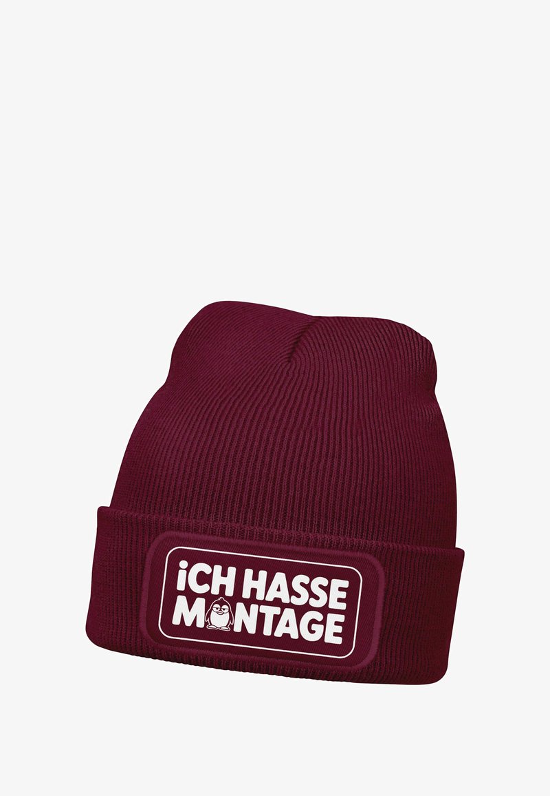 Maroon knitted beanie with a ribbed texture, featuring a white rectangular patch with the text "ICH HASSE MONTAGE" and a small cartoon character.