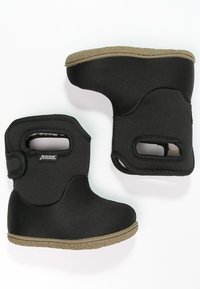 Botas impermeables negras con tejido texturizado, diseño curvado y asas laterales. Suelas de goma marrón con un patrón de dibujo para una mejor tracción.